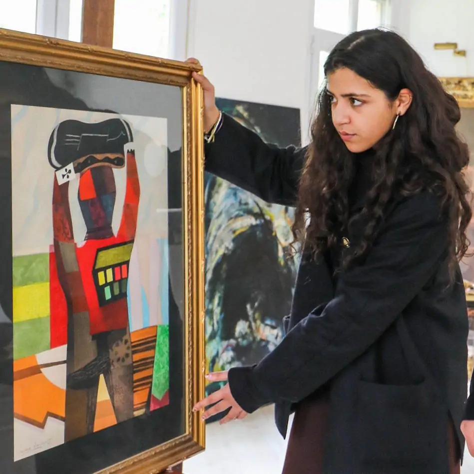 Expert antiquaire Experte antiquaire expertissant un tableau moderne