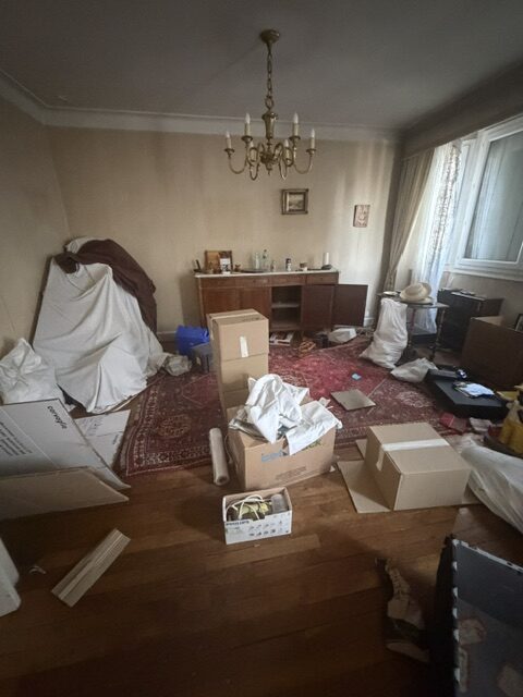 Chambre en désordre avec des cartons avant débarras à paris