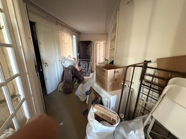 Débarras d'un appartement et de cinq caves, Paris 14e : rue de l'Observatoire, cinquième étage 11 couloir rempli d'objets pendant le débarras
